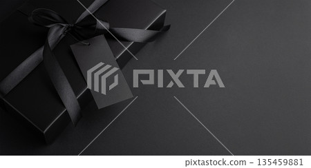 Black Gift Box with Satin Ribbon and Blank Tag. Luxury Packaging for Black Friday Promotion Black Gift Box with Satin Ribbon and Blank Tag. Luxury Packaging for Black Friday Promotion 135459881