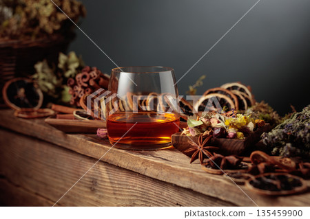 Herbal liquor and natural ingredients like herbs, roots, dried citrus slices, spices visible. 135459900