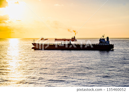 Cargo ships sailing at sunset, towards the port of Barcelona Cargo ships sailing at sunset, towards the port of Barcelona 135460052