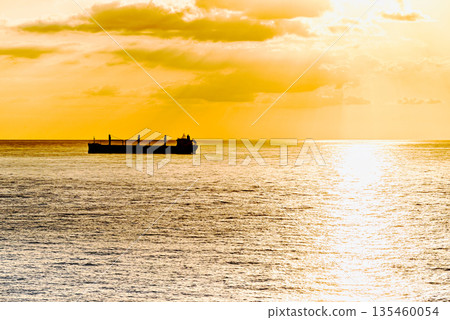 Cargo ships sailing at sunset, towards the port of Barcelona Cargo ships sailing at sunset, towards the port of Barcelona 135460054