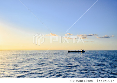 Cargo ships sailing at sunset, towards the port of Barcelona Cargo ships sailing at sunset, towards the port of Barcelona 135460057