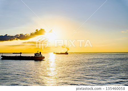 Cargo ships sailing at sunset, towards the port of Barcelona Cargo ships sailing at sunset, towards the port of Barcelona 135460058