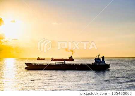 Cargo ships sailing at sunset, towards the port of Barcelona Cargo ships sailing at sunset, towards the port of Barcelona 135460063