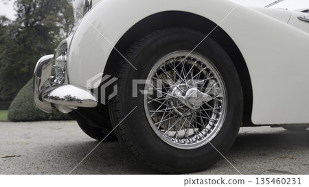 White vintage car wheel detail on asphalt road. Action 135460231