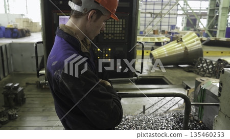 Factory worker monitoring cnc machine operation. Stock clip 135460253