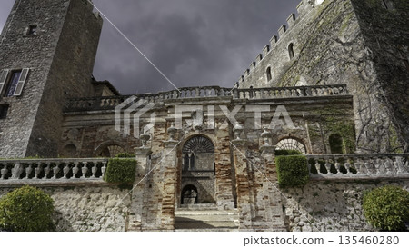 Majestic castle entrance under dramatic cloudy sky. Action 135460280