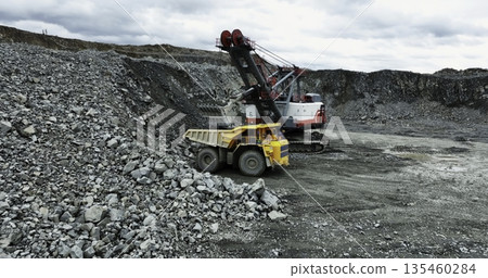 Excavator loading dump truck in open pit mine. Stock clip 135460284