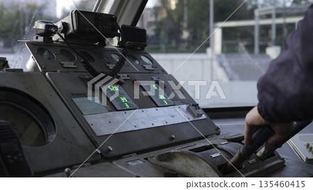 Train driver operating levers and controls in cabin. Clip Train driver operating levers and controls in cabin. Clip 135460415