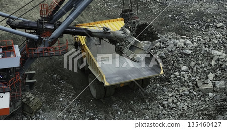 Excavator loading dump truck in quarry. Stock clip 135460427