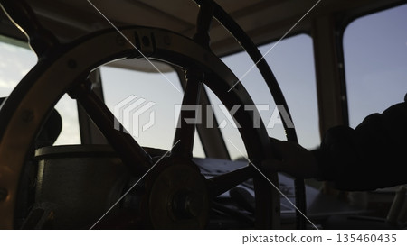 Captain steering ship through calm waters at sunrise. Clip Captain steering ship through calm waters at sunrise. Clip 135460435