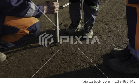 Surveyor measuring ground level with wooden ruler. Clip Surveyor measuring ground level with wooden ruler. Clip 135460442
