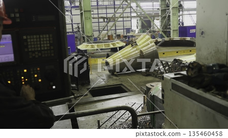 Factory worker operating cnc machine for metal part manufacturing. Stock clip 135460458