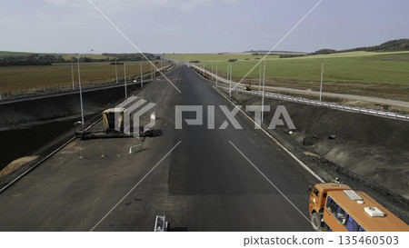 Highway construction progress: laying asphalt and installing streetlights. Clip Highway construction progress: laying asphalt and installing streetlights. Clip 135460503