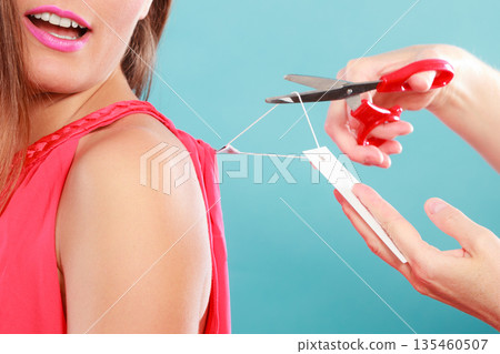 Woman cutting off removing label board price tag. Woman cutting off removing label board price tag. 135460507