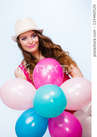 Woman playing with many colorful balloons Woman playing with many colorful balloons 135460520