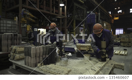 Foundry workers preparing molds for metal casting. Stock clip Foundry workers preparing molds for metal casting. Stock clip 135460607