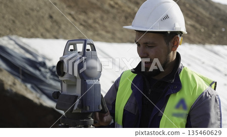 Surveyor using theodolite on construction site. Clip 135460629