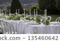 Elegant white table setting with candles and flowers in garden. Action 135460642