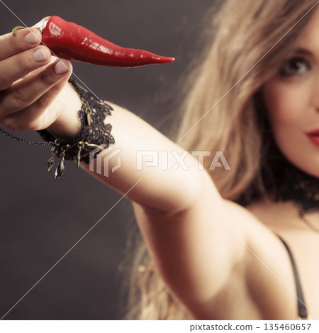 Woman wearing lingerie holding chilli pepper 135460657
