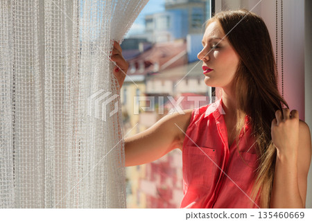 Woman looking through window, relaxing Woman looking through window, relaxing 135460669