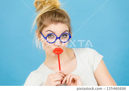 Happy woman holding fake lips on stick 135460886