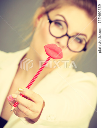Happy elegant woman holding carnival accessoies on stick Happy elegant woman holding carnival accessoies on stick 135460889