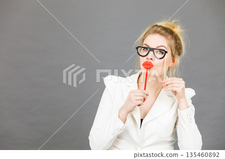 Happy elegant woman holding carnival accessoies on stick Happy elegant woman holding carnival accessoies on stick 135460892