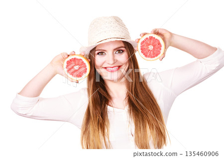 Woman holds two halfs of grapefruit citrus fruit in hands Woman holds two halfs of grapefruit citrus fruit in hands 135460906