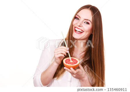 Woman holds grapefruit drinking juice from fruit Woman holds grapefruit drinking juice from fruit 135460911