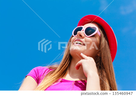 Woman wearing heart shaped sunglasses and hat Woman wearing heart shaped sunglasses and hat 135460947