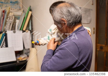 Elderly man holding his grandson Elderly man holding his grandson 135462398