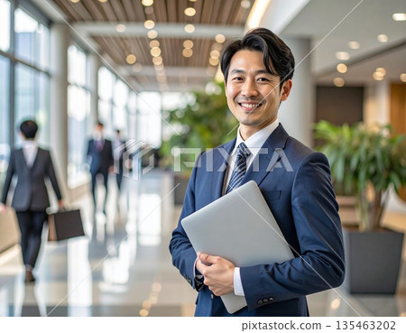 辦公室裡，一位商務人士站在電腦前。 135463202