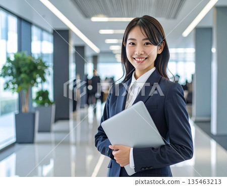 辦公室裡,一位商務人士站在電腦前。 辦公室裡,一位商務人士站在電腦前。 135463213