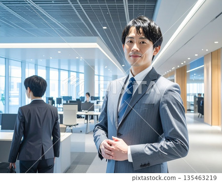 辦公室裡,一位商務人士站在電腦前。 辦公室裡,一位商務人士站在電腦前。 135463219