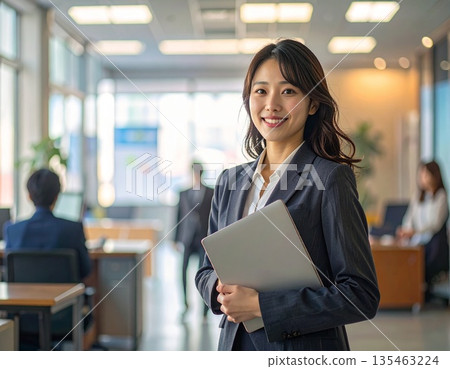 辦公室裡,一位商務人士站在電腦前。 辦公室裡,一位商務人士站在電腦前。 135463224