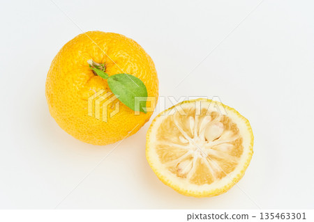 A yuzu cut in half photographed against a white background A yuzu cut in half photographed against a white background 135463301