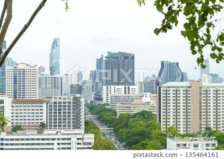 Elevated view of Bangkok cityscape featuring modern skyscrapers like MahaNakhon and lush green urban parks. High-angle perspective of city traffic and architectural diversity in Thailand. Elevated view of Bangkok cityscape featuring modern skyscrapers like MahaNakhon and lush green urban parks. High-angle perspective of city traffic and architectural diversity in Thailand. 135464161