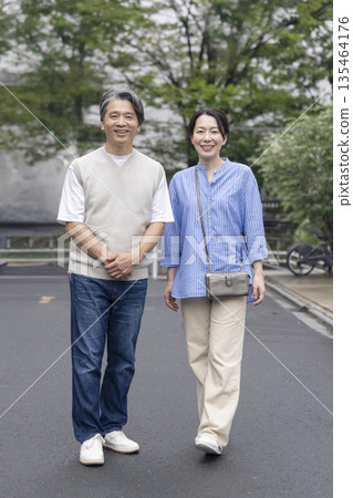 一對 50 多歲的夫婦對著鏡頭微笑 一對 50 多歲的夫婦對著鏡頭微笑 135464176