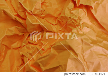 Close-up full frame texture of vibrant orange crumpled and wrinkled paper. Perfect for creative backgrounds, design projects, and abstract patterns with dynamic shadows and highlights 135464421