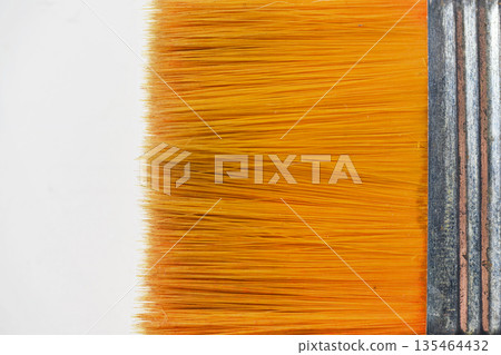 Macro view of a flat paintbrush with vibrant orange synthetic bristles and a metal ferrule. Isolated on a white background, perfect for art, craft, and renovation concepts Macro view of a flat paintbrush with vibrant orange synthetic bristles and a metal ferrule. Isolated on a white background, perfect for art, craft, and renovation concepts 135464432