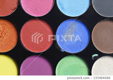 Macro shot of a professional makeup palette featuring various bright and matte eyeshadow shades. Perfect for beauty, fashion, and cosmetic themes 135464480