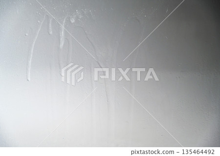 A close-up view of a gray painted surface featuring vertical liquid streaks and drips, creating a grunge industrial background for design projects A close-up view of a gray painted surface featuring vertical liquid streaks and drips, creating a grunge industrial background for design projects 135464492