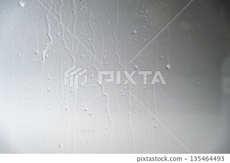 A close-up view of a gray painted surface featuring vertical liquid streaks and drips, creating a grunge industrial background for design projects A close-up view of a gray painted surface featuring vertical liquid streaks and drips, creating a grunge industrial background for design projects 135464493