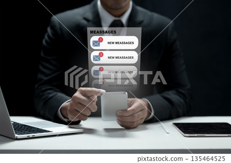 Professional businessman in a suit using a smartphone with virtual message notifications and alerts appearing. Concept of digital communication, technology, and business productivity 135464525