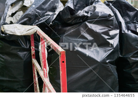 Metal red fencing,polypropylene filled bags with garbage.Cleaning Metal red fencing,polypropylene filled bags with garbage.Cleaning 135464655
