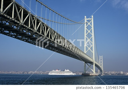 Distant view of a cruise ship passing through the Akashi Kaikyo Bridge 135465706