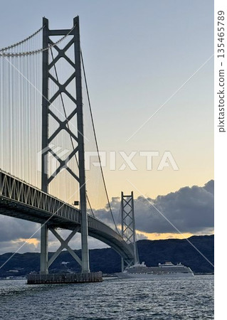 Evening view of a cruise ship passing through the Akashi Kaikyo Bridge Evening view of a cruise ship passing through the Akashi Kaikyo Bridge 135465789