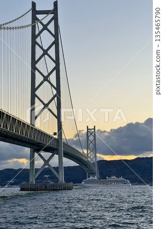 Evening view of a cruise ship passing through the Akashi Kaikyo Bridge 135465790
