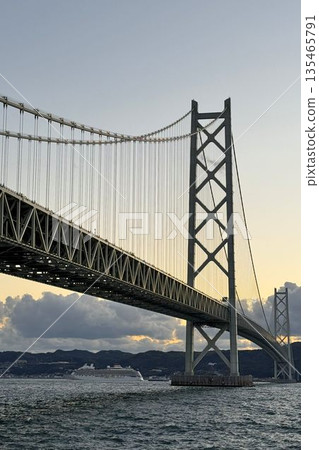 傍晚時分，一艘遊輪駛過明石海峽大橋。 135465791