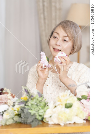 一位老婦人在客廳以插花為樂 135466910